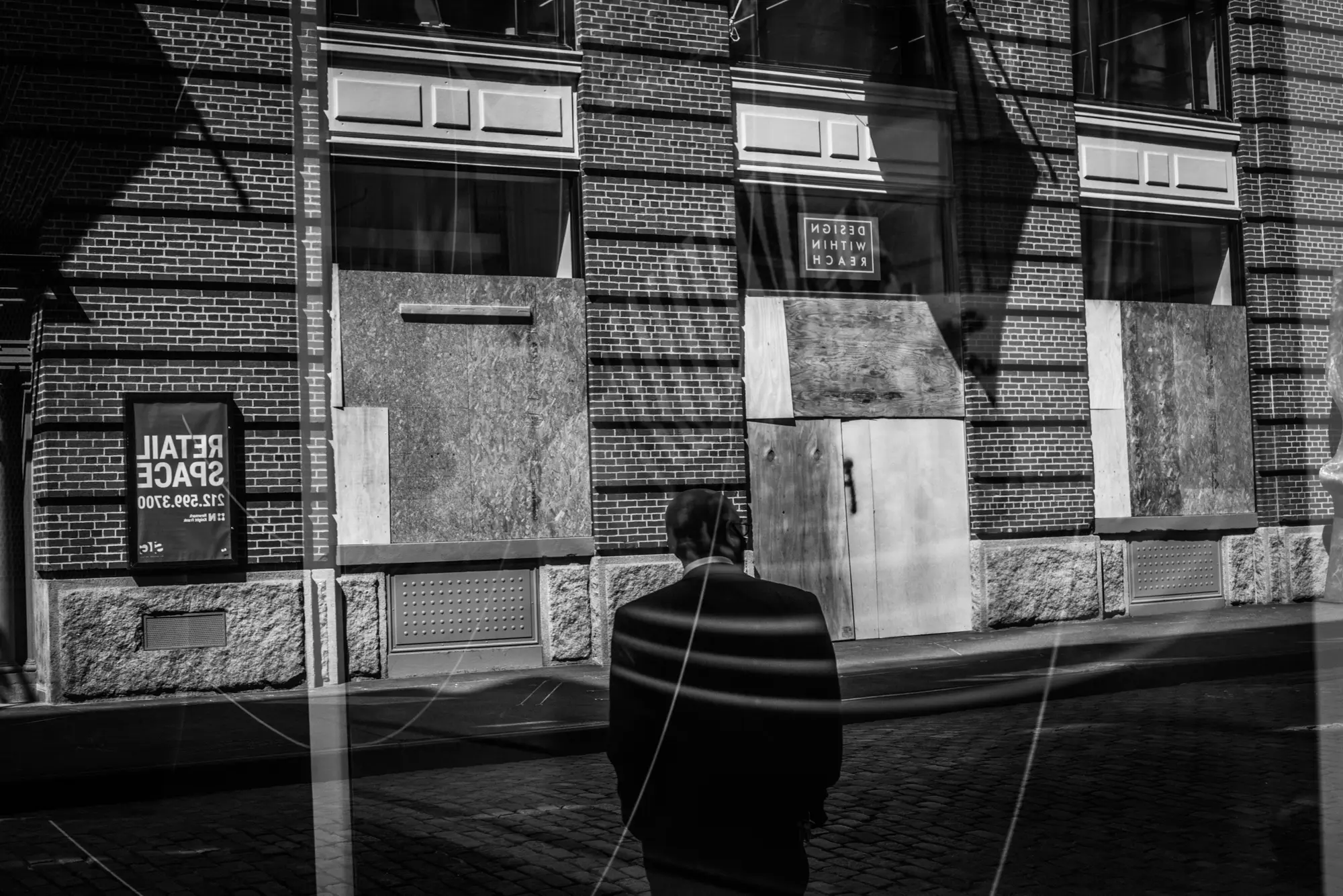 Boarded storefront and solitary figure